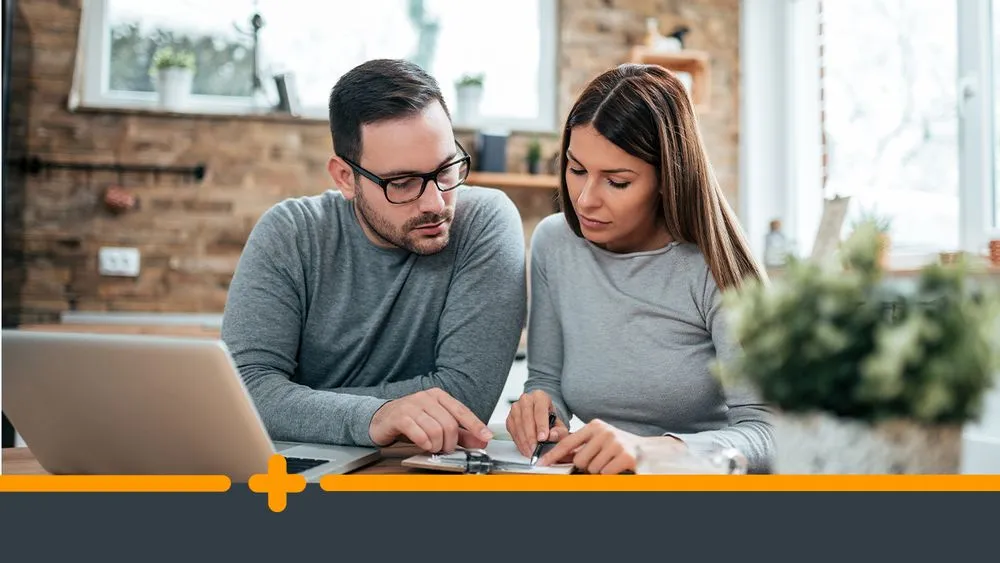 Zamartwiona para omawia formalności finansowe przy komputerze